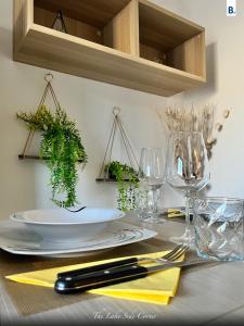 a table with a white plate and some glasses and plants at [The LaKe-SiDe CorNer] Apartment in Como