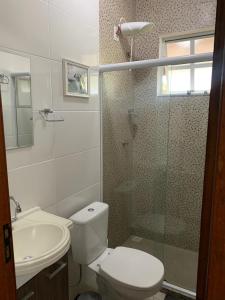 ein Bad mit einem WC, einer Dusche und einem Waschbecken in der Unterkunft Casa Brisa Tropical in Rio das Ostras