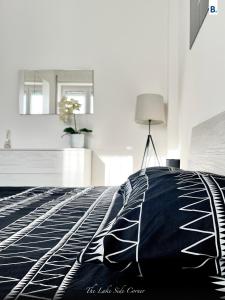 a bedroom with a bed with a black and white blanket at [The LaKe-SiDe CorNer] Apartment in Como