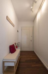 a white room with a bench with a red pillow on it at Apartment Sun&Moon in Venice in Mestre