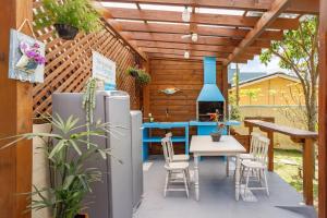 a patio with a table and chairs and a stove at BANGALOS FLORIANÓPOLIS in Florianópolis