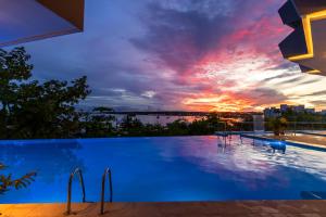 a swimming pool with a view of a sunset at Grand Sirenis San Andres in San Andrés