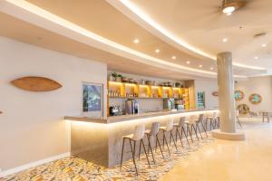 a bar with a row of stools in a room at Grand Sirenis San Andres in San Andrés