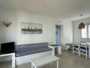 a living room with a couch and sailboats on the wall at Villa Pont d'En Gil in Cala en Blanes