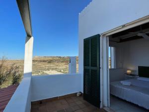 a room with a bed and a balcony with a view at Villa Pont d'En Gil in Cala en Blanes