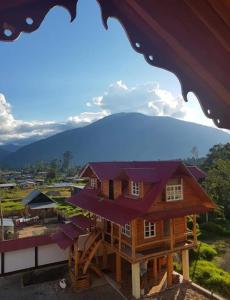 una casa en un stand con una montaña en el fondo en Hospedaje Lojada, en Oxapampa