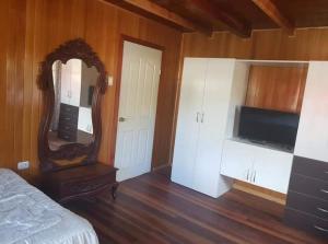 a bedroom with a mirror and a bed and a tv at Hospedaje Lojada in Oxapampa