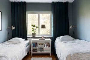 two twin beds in a room with a window at Stor villa nära till centrala Stockholm in Stockholm