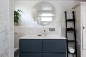La salle de bains est pourvue d'un lavabo et d'un miroir. dans l'établissement Stor villa nära till centrala Stockholm, à Stockholm