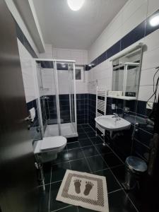 een badkamer met 2 wastafels, een douche en een toilet bij Fantastik Ayaz Apartments in Ohrid