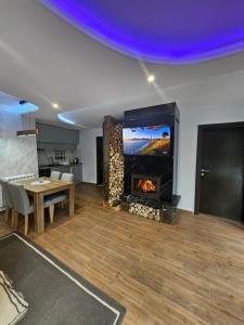 a living room with a fireplace and a dining table at Apartman Jovanic in Divčibare