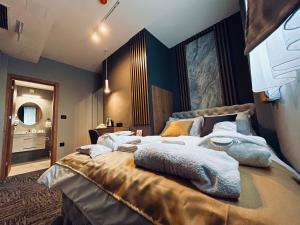 een slaapkamer met een groot bed in een kamer bij MOZAIK Apartments & Spa - Modern Apartments with Exclusive Spa Wellness in the City Center, Free Parking, Wi-FI, Sauna, Jacuzzi, Salt Wall in Ćuprija