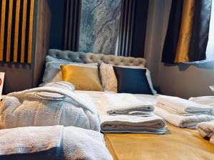 a bed with towels sitting on it in a room at MOZAIK Apartments & Spa - Modern Apartments with Exclusive Spa Wellness in the City Center, Free Parking, Wi-FI, Sauna, Jacuzzi, Salt Wall in Ćuprija