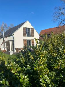 Una casa blanca con un árbol delante. en Ferienhaus Annemie, en Markt Erlbach