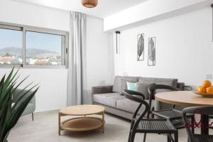 a living room with a couch and a table and chairs at Modern family apartment next to the sea - By Edomlux in Eilat