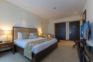 a bedroom with a large bed and a flat screen tv at Spacious, Modern Studio in Marina Dubai in Dubai