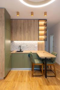 a kitchen with a wooden table and green cabinets at ADRIATIC VIEW M in Bar +6 photos