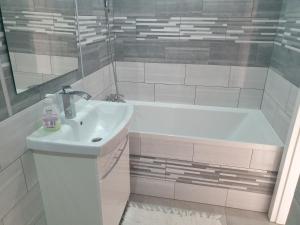 y baño blanco con lavabo y bañera. en Apartament Laurka, en Kamienna Góra