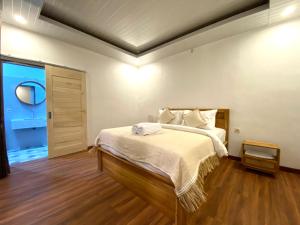 a bedroom with a large bed with a wooden floor at Brahmastra Bali villa in Kubupenlokan