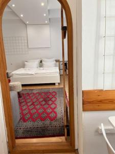 een slaapkamer met een bed en een deuropening met een kleed bij Srce Sarajeva in Sarajevo