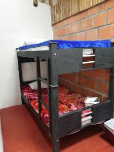 two bunk beds in a room with a brick wall at HOSTAL MACONDO in Manizales