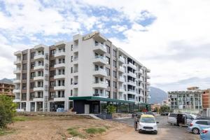 a large white building with cars parked in a parking lot at ADRIATIC VIEW M in Bar