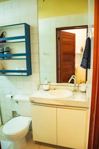 ein Badezimmer mit einem WC, einem Waschbecken und einem Spiegel in der Unterkunft Apto a 350m da Praia de Ponta Verde, em Maceio AL in Maceió