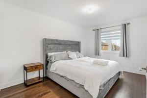 a white bedroom with a large bed and a window at Spacious Home! 5 King Beds, 1 Queen, Modern Luxury, Free Parking in Pointe-Claire