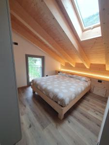 a bedroom with a bed in a room with a skylight at La ciöda Malenca in Cave dʼArdesia
