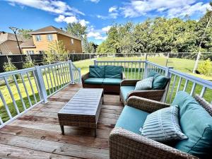 a deck with couches and a table on a porch at Spacious Home! 5 King Beds, 1 Queen, Modern Luxury, Free Parking in Pointe-Claire