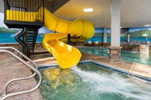 a pool with a yellow slide in the water at La Quinta Inn & Suites by Wyndham Lake George in Lake George