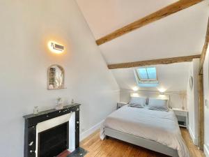 a bedroom with a bed and a fireplace at La Demeure des Hôtes 10 minutes de Disney in Couilly-Pont-aux-Dames