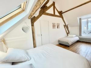 a bedroom with two beds and a window at La Demeure des Hôtes 10 minutes de Disney in Couilly-Pont-aux-Dames