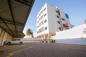 a white car parked in a parking lot in front of a building at Flats Andira Kuss in Sinop