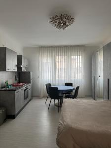 Habitación con cama, mesa y cocina. en Monolocale Centro storico, en Pordenone