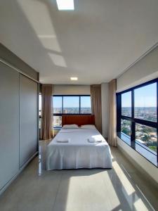 sypialnia z dużym łóżkiem i dużymi oknami w obiekcie Estudio Alto e Aconchegante no 32º andar do Vertigo w mieście Campo Grande