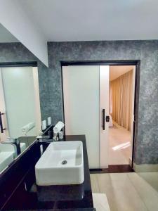 a bathroom with a white sink and a mirror at Estudio Alto e Aconchegante no 32º andar do Vertigo in Campo Grande