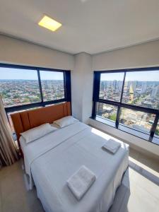 a bedroom with two beds and large windows at Estudio Alto e Aconchegante no 32º andar do Vertigo in Campo Grande