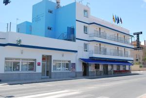 a building on the corner of a street at Hotel Trabuco in Santiago de la Ribera