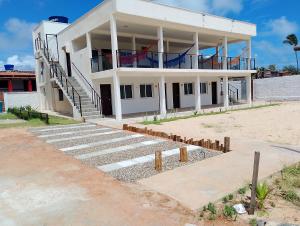ein weißes Gebäude mit einer Treppe davor in der Unterkunft Apartamento Casal beira mar, Ventos de Sibaúma in Tibau do Sul