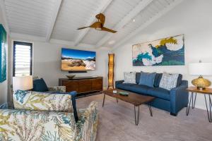 ein Wohnzimmer mit einem blauen Sofa und einem Tisch in der Unterkunft Luxurious Wailea Ocean Vistas in Wailea