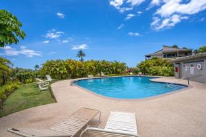 ein Swimmingpool mit Stühlen und ein Haus in der Unterkunft Luxurious Wailea Ocean Vistas in Wailea