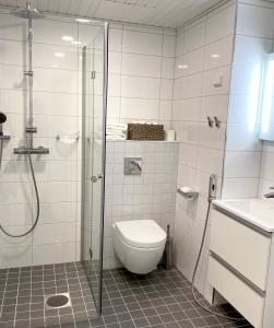 a bathroom with a shower and a toilet and a sink at Modern apartment in a prime location in Helsinki