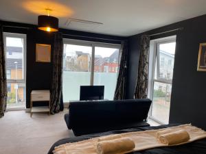 a bedroom with a bed and a large window at Family & Business Stays In RG2 - Sleeps Up to 12! in Reading