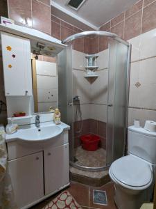 uma casa de banho com um chuveiro, um WC e um lavatório. em Artistica Apartment Skopje, 2 bdr em Skopje