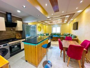 een keuken en een woonkamer met een tafel en stoelen bij Luxurious Scandinavian-style with swimming pool and play area - Fast wifi in Oued Laou