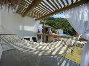 uma rede pendurada numa casa com vista em Santomar Guest House em Ilhabela