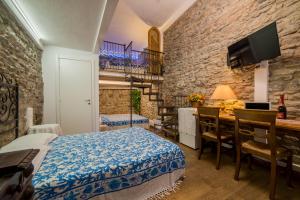 a bedroom with a bed and a table with a desk at The Vernazza Main Plaza - Rooms & Suites in Vernazza