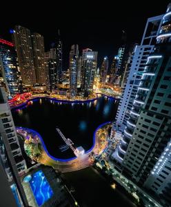 a view of a city at night with a river and buildings at Amazing 1 bedroom apt in Marina in Dubai