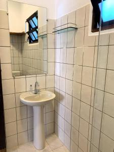 un baño con lavabo y espejo en Suítes Maresias, en Maresias